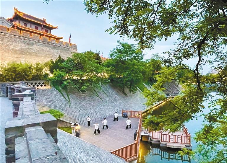 市民在护城河边练习太极拳。 (记者 王旭东 摄 资料图片)